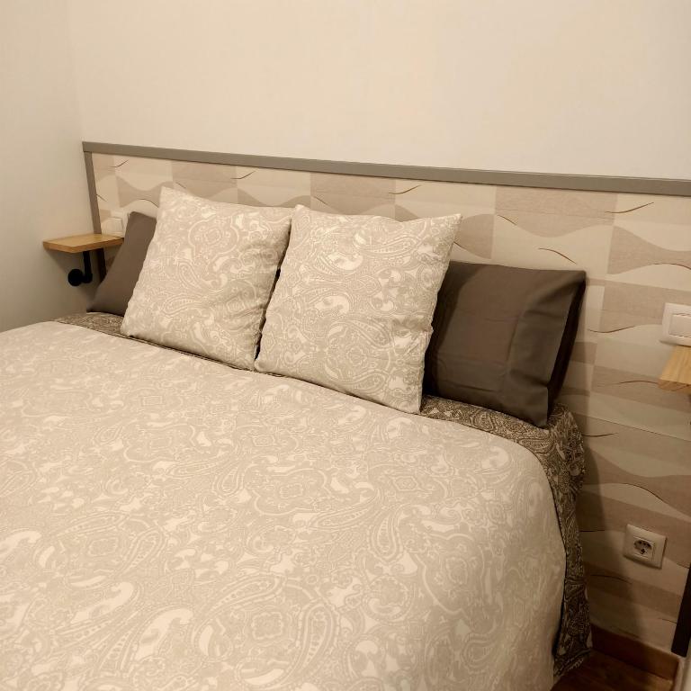 a bed with a headboard and pillows in a bedroom at Cornisa Tourists Home in Toledo