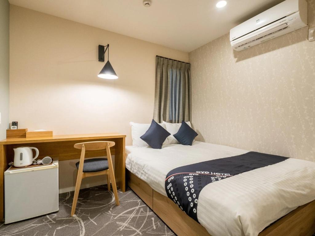 una habitación de hotel con una cama y un escritorio en I GO Hotel, en Tokio