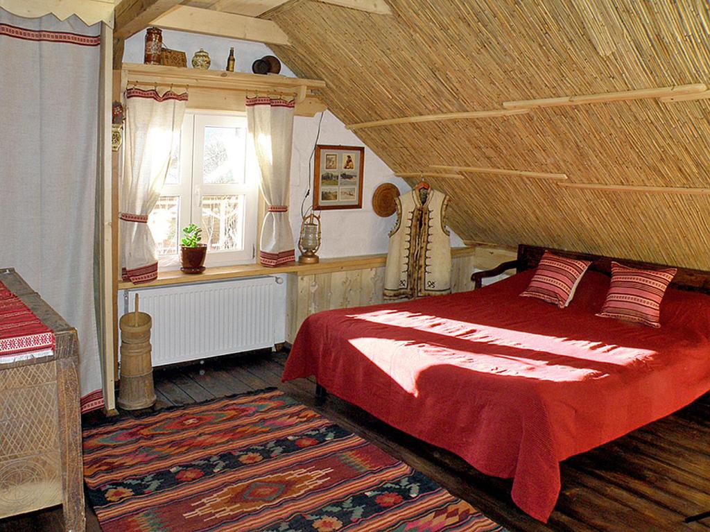 a bedroom with a red bed and a window at Salamandra Village in Kozevo