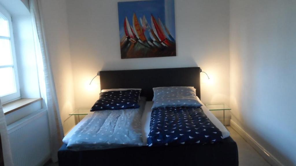 a bed in a room with a painting on the wall at Ferienwohnung Gurvitz in Rambin