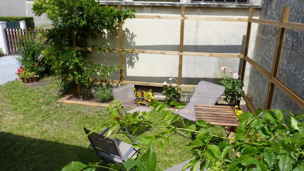 a garden with two chairs and a bench in the grass at Apartment Le Jardinet in Talence