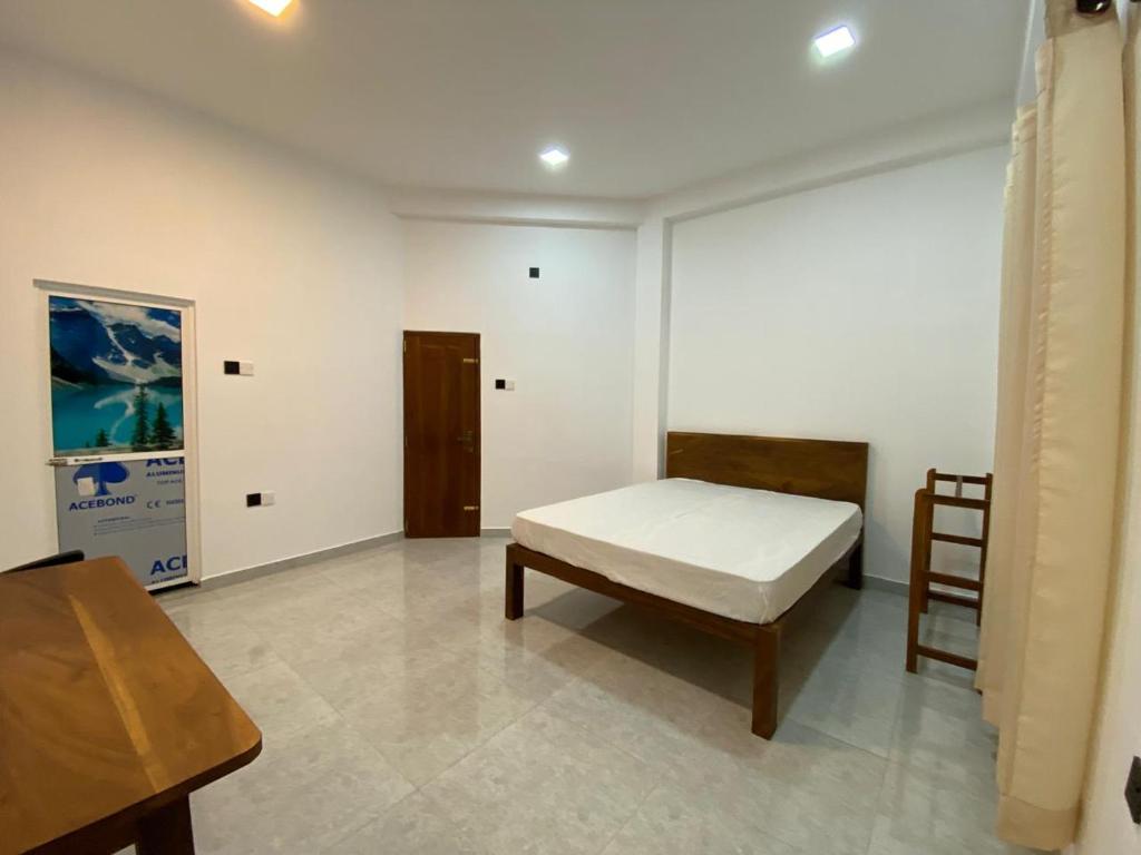 a room with a bed and a table and a chair at Crystal house in Weligama