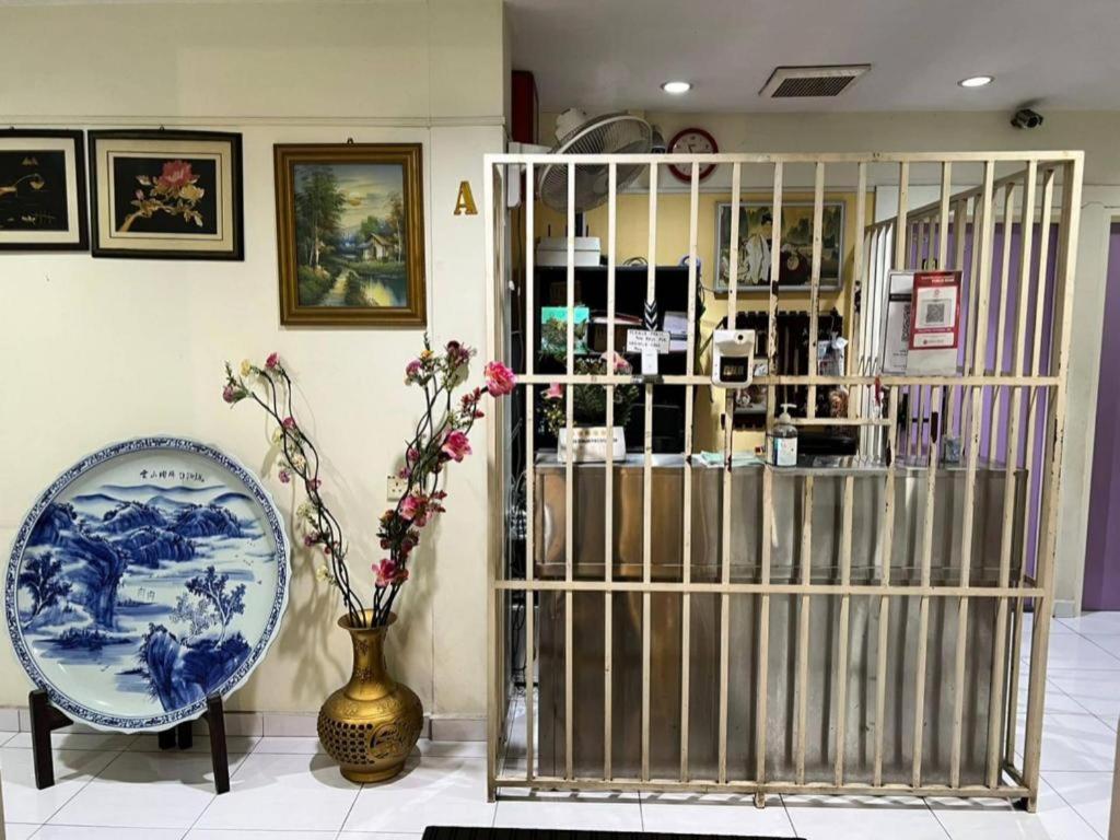 a room with a gate and a vase with flowers at OYO 90994 Hotel Golden Mouse in Sultan Azlan Shah Airport