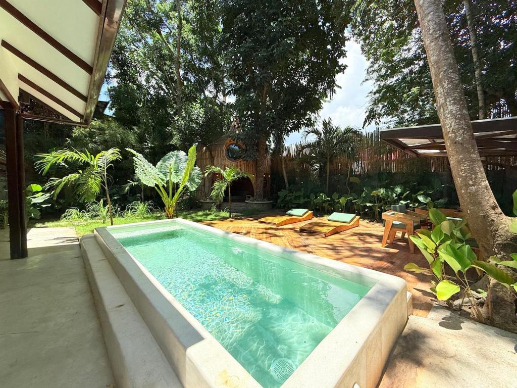 a swimming pool in a yard with chairs and a house at Alitaptap Villa by Lugadia Villas in El Nido