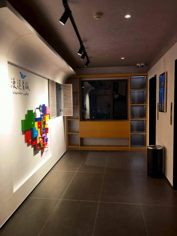 a room with a wall with a painting on it at Wander Lodge Youth Hostel in Chengdu