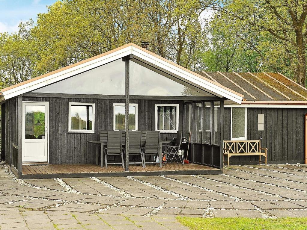 a small cabin with chairs on a wooden deck at 6 person holiday home in Ansager-By Traum in Ansager