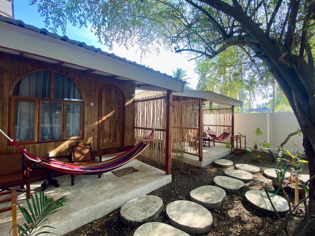 a hammock on the porch of a house at Gaia cottages in Gili Trawangan