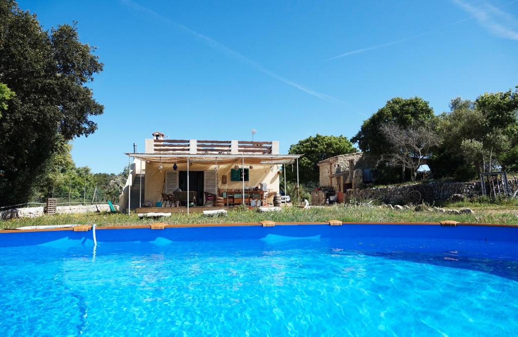 une maison avec une piscine devant dans l'établissement Son Aloui Mallorca, à Llubí