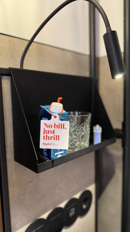 A wall-mounted reading light illuminates a small drinks-and-snacks shelf.