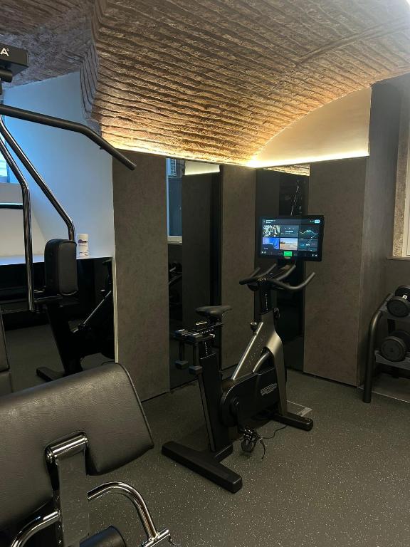 A compact hotel gym with a stationary bike, cardio equipment and weight machines.