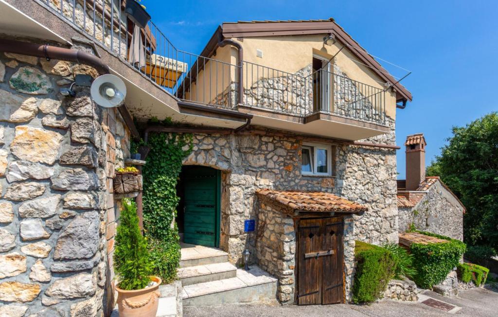 a stone house with a wooden door and a balcony at Beautiful Stone House Obrs with indoor pool in Kraj