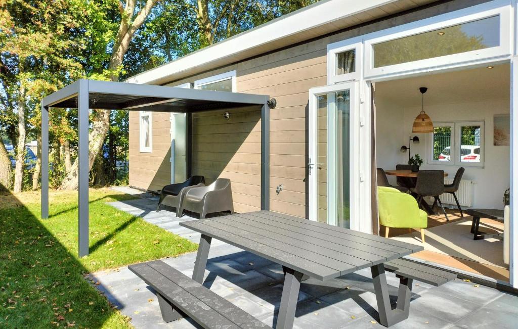 a picnic table on a patio in front of a house at Lovely Home In Heinkenszand With Heated Swimming Pool in Heinkensand