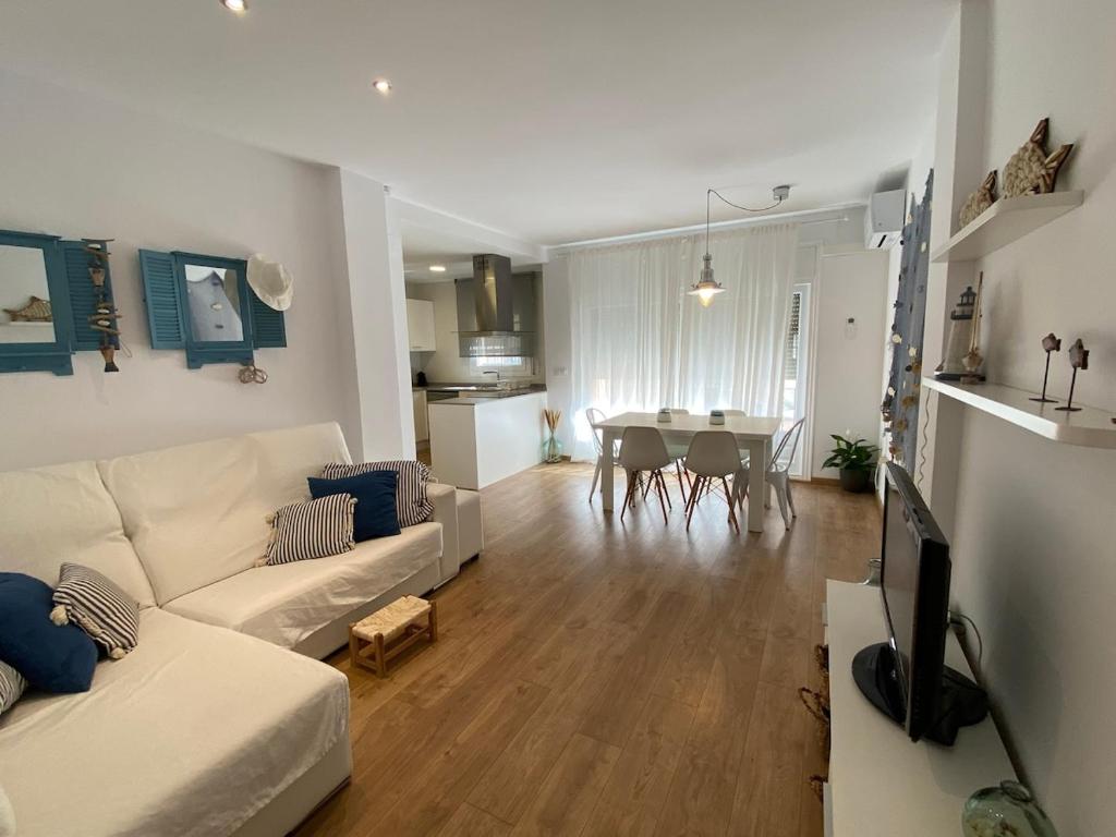 a living room with a white couch and a table at Casa Cris Palamos in Palamós