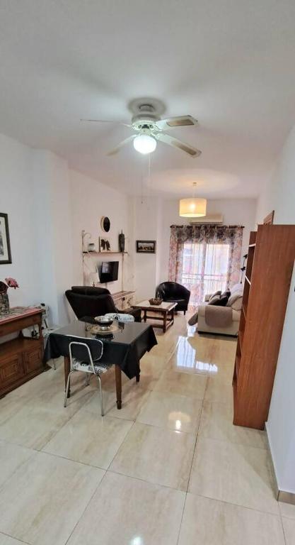 a living room with a couch and a ceiling fan at Apartamento Calle Real in Martos