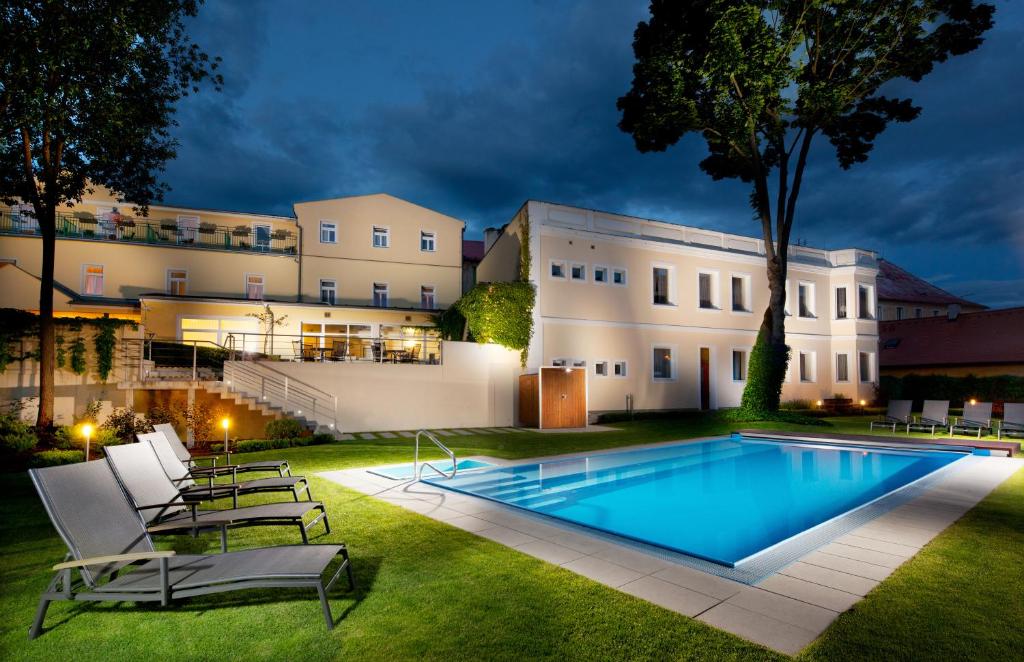 um quintal com uma piscina e um edifício em Hotel Reza em Františkovy Lázně