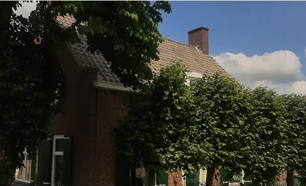 a brick building with a tree in front of it at BonAparte Kamer 3 in Hank