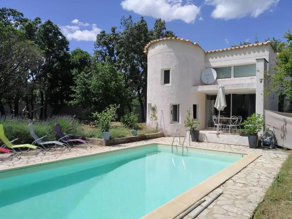 a swimming pool in front of a house at Maison charmante à Saint-Siffret + Piscine in Saint-Siffret