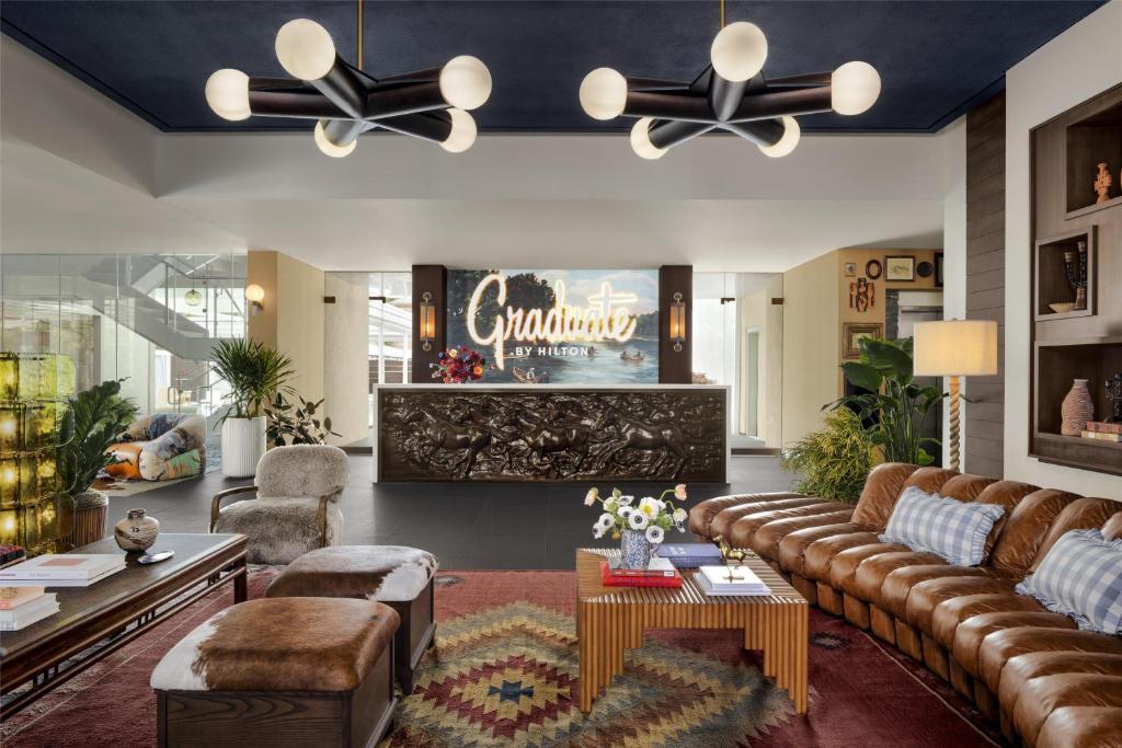 sala de estar amplia con sofá y mesa en Graduate by Hilton Dallas, en Dallas