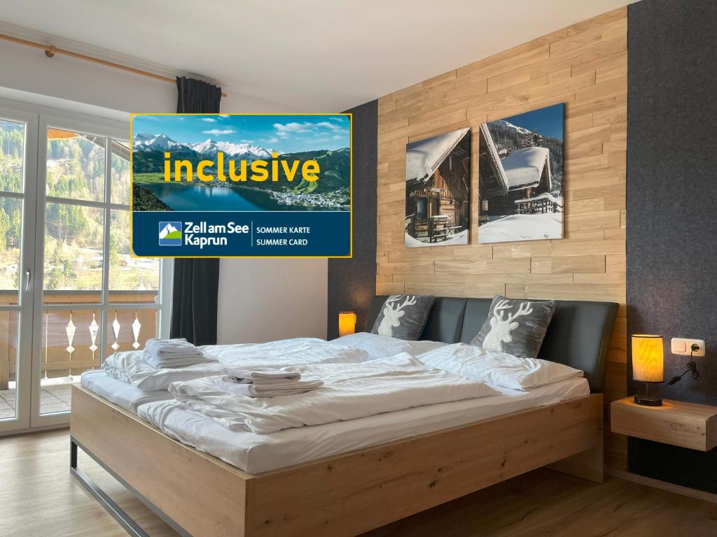 a bed in a room with a poster on the wall at Gipfelglueck Kaprun - Summer Card included! in Kaprun