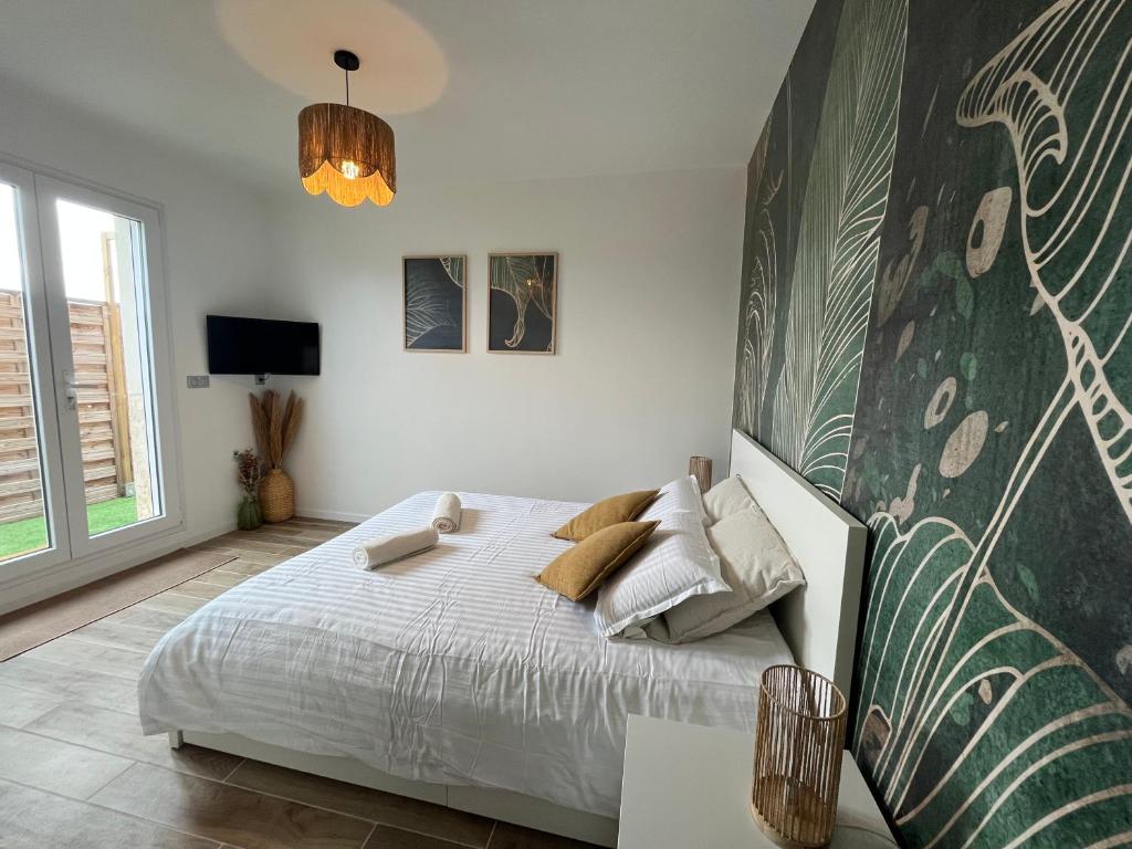 a bedroom with a large bed and a large wall at La chambre de Bodhi 