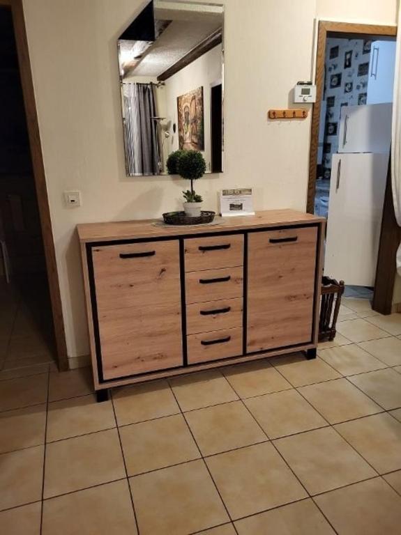 a large wooden cabinet in a kitchen with a mirror at Haus Waldfrieden EG in Thalfang