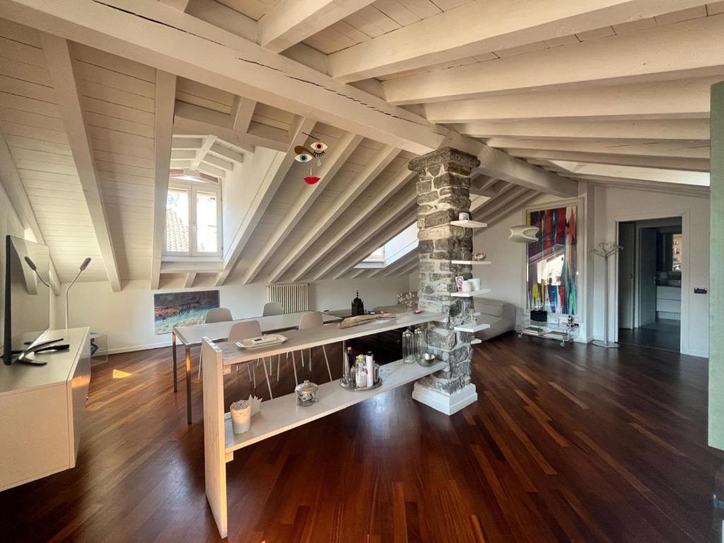 a large room with wooden floors and a stone pillar at Vanessa's Art Rooftop Attic - City View - San Fedele, Historic Center Como in Como