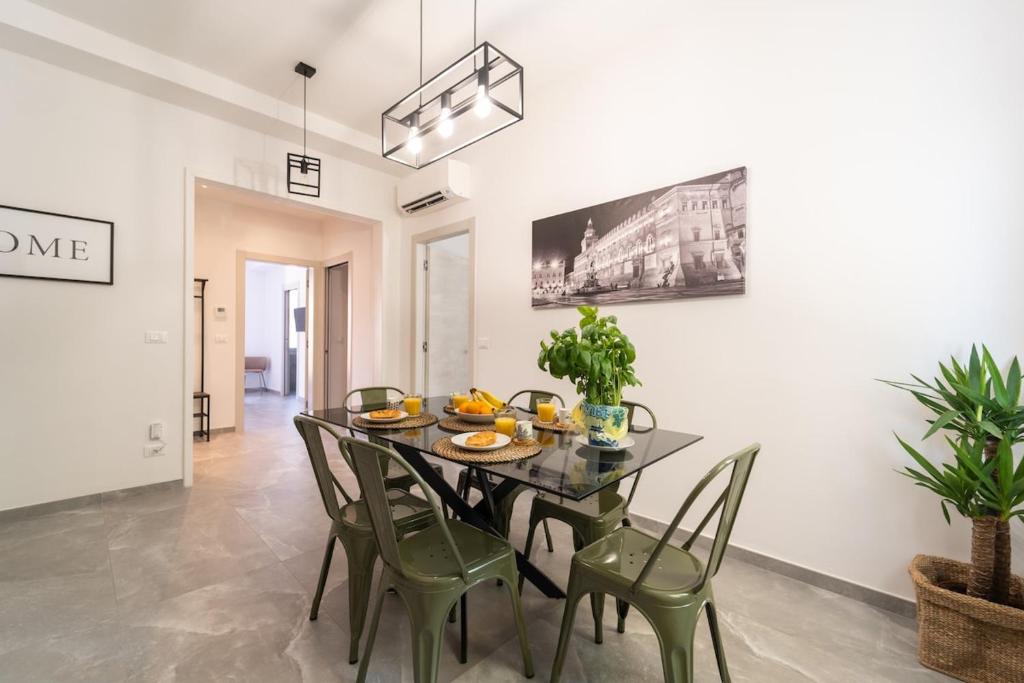 a dining room with a black table and green chairs at Luxury Station Oasis with Balcony in Bologna