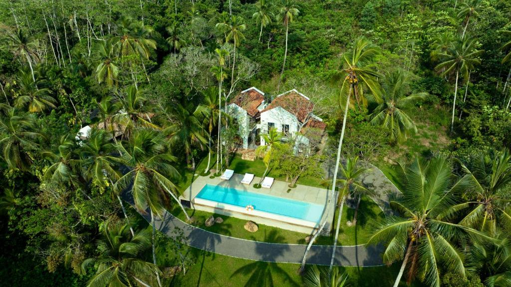 an aerial view of a house with a swimming pool in the forest at Sa House - Talpe in Galle
