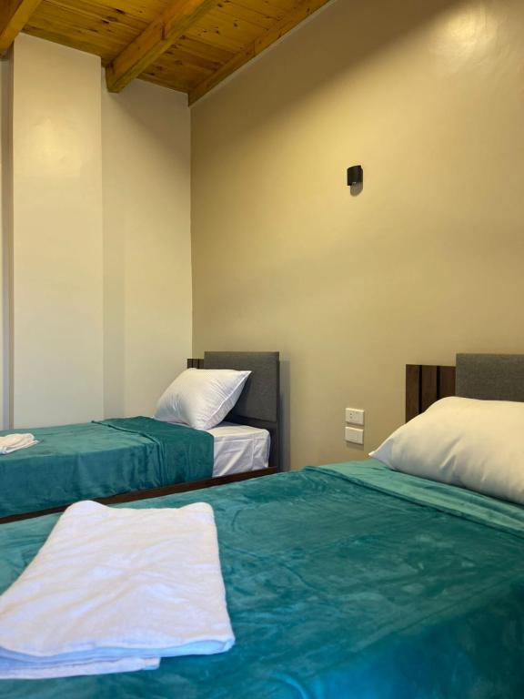 a bedroom with two beds with green and white sheets at Luxor Thames apartment in Luxor