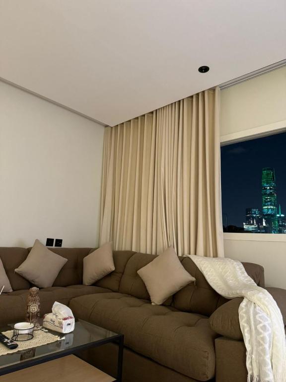 a living room with a brown couch and a window at Studio in Al-Aqiq شقه رقم 15 و in Riyadh
