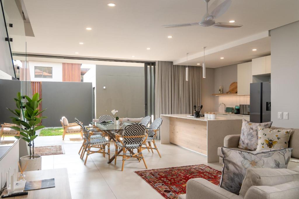 a kitchen and living room with a table and chairs at Zimbali Luxury Garden Villa in Ballito