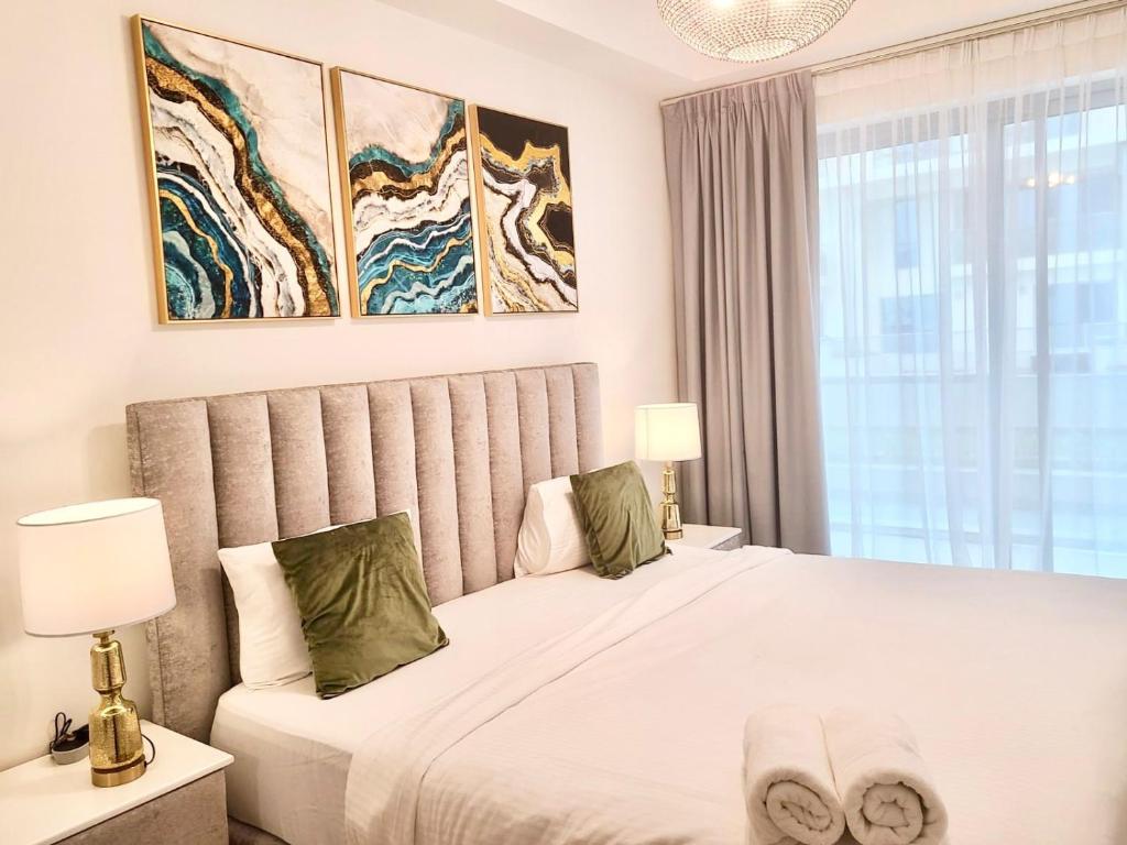 a bedroom with a large white bed and a window at Stylish 2BR Duplex Apartment with Balcony & Access to Pool in Ras al Khaimah