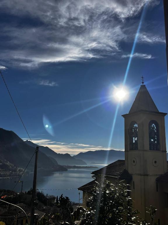 a church with a clock tower with a view of a lake at Little Lake Escape in Olgiasca