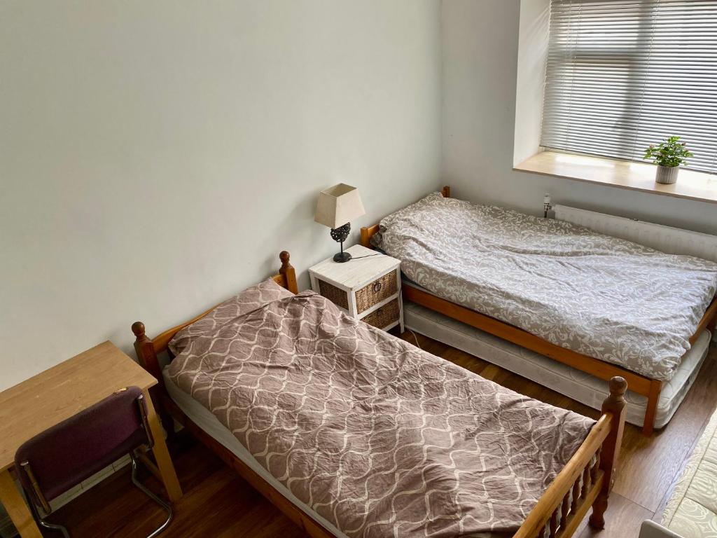 two twin beds in a room with a window at Blue Beach in Hove