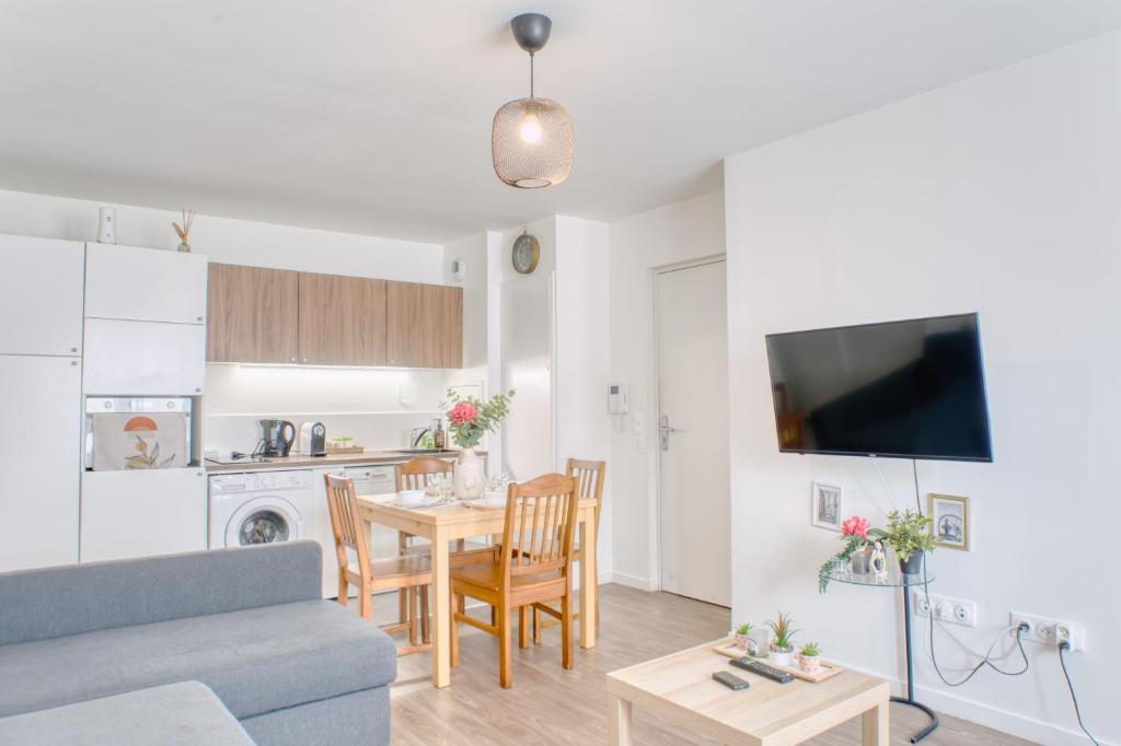 sala de estar y cocina con mesa y sofá en Appartement agréable Parking inclus, en Aubervilliers