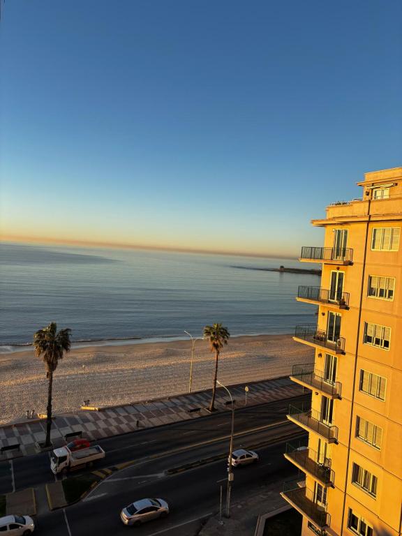 a view of a building and a beach with palm trees at Frente al mar in Montevideo