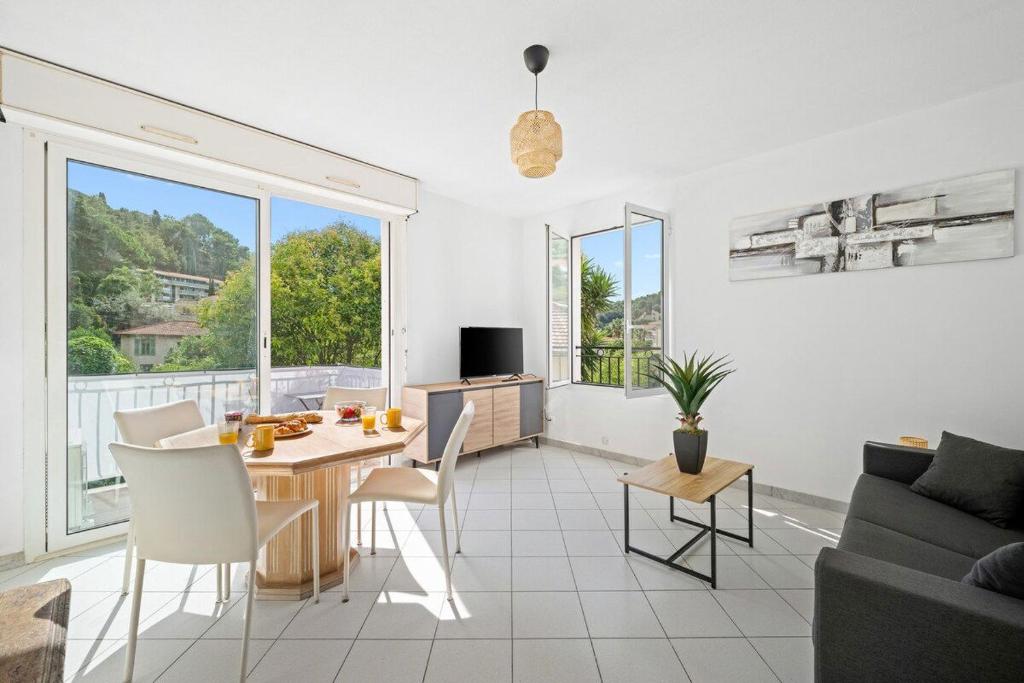 a living room with a table and a couch at Villa Julia -Calme Spacieux - Parking Privé - Clim in Menton