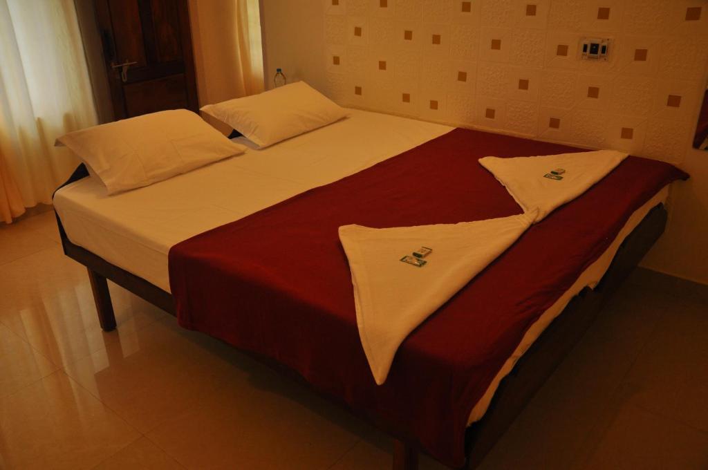 a bed with white sheets and pillows on it at Palm View Residency in Varkala
