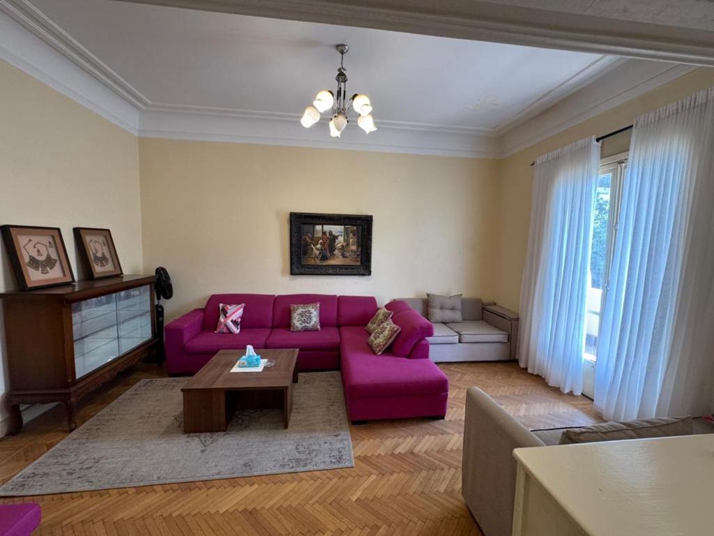 a living room with a purple couch and a table at Prime location 2 bed rooms Apartment , near the Nile & Cairo Center in Cairo