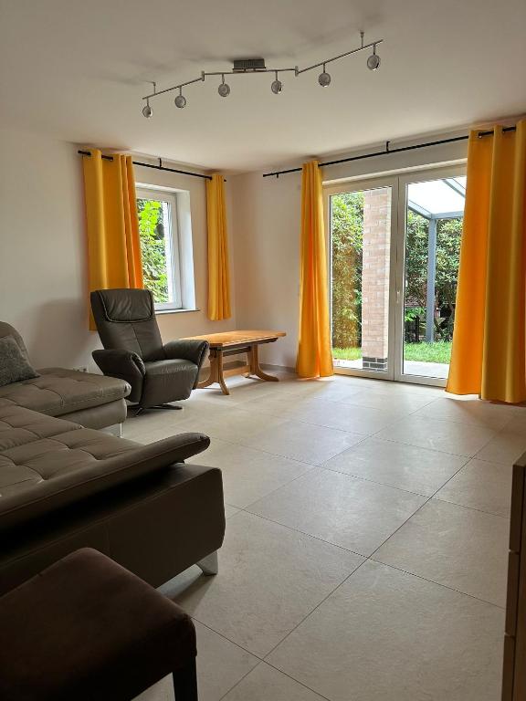 a living room with a couch and a table and yellow curtains at Zwei Buchen in BRE
