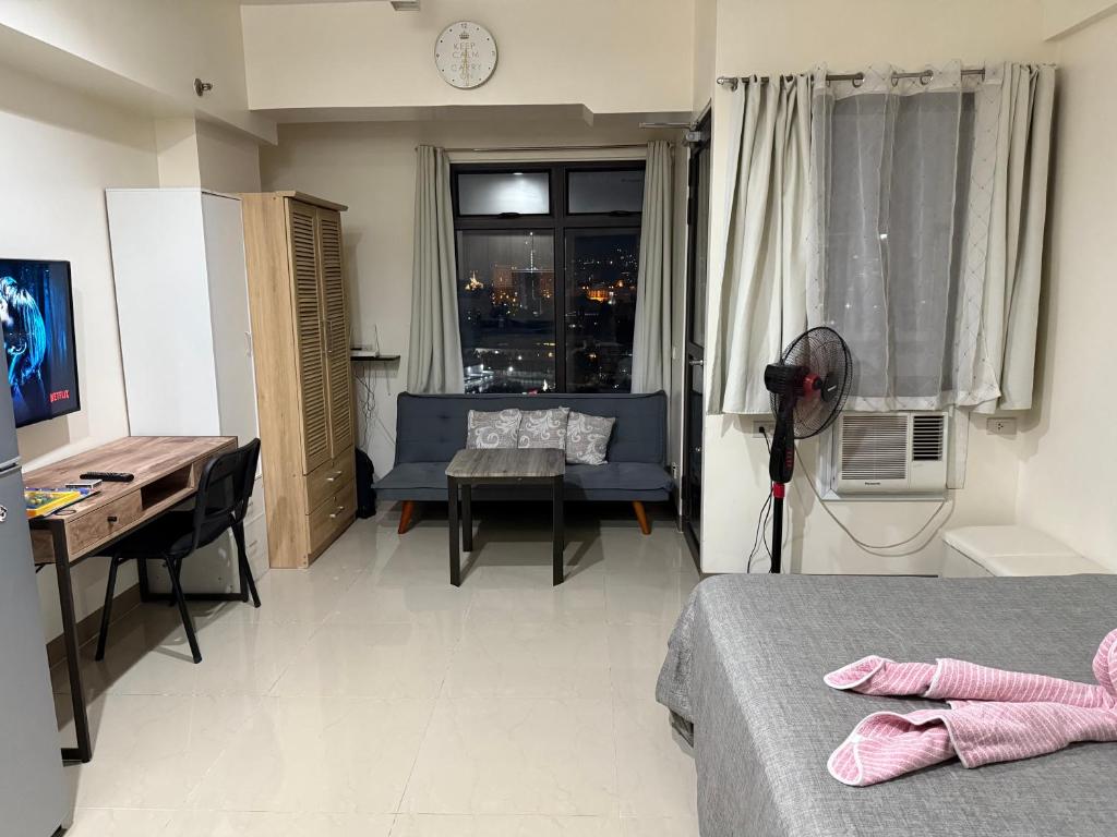 a room with two beds and a desk and a window at Heart of Cebu Cozy Studio with Pool, Gym, Wifi and Netflix near Cebu City,Ayala and IT Park in Cebu City