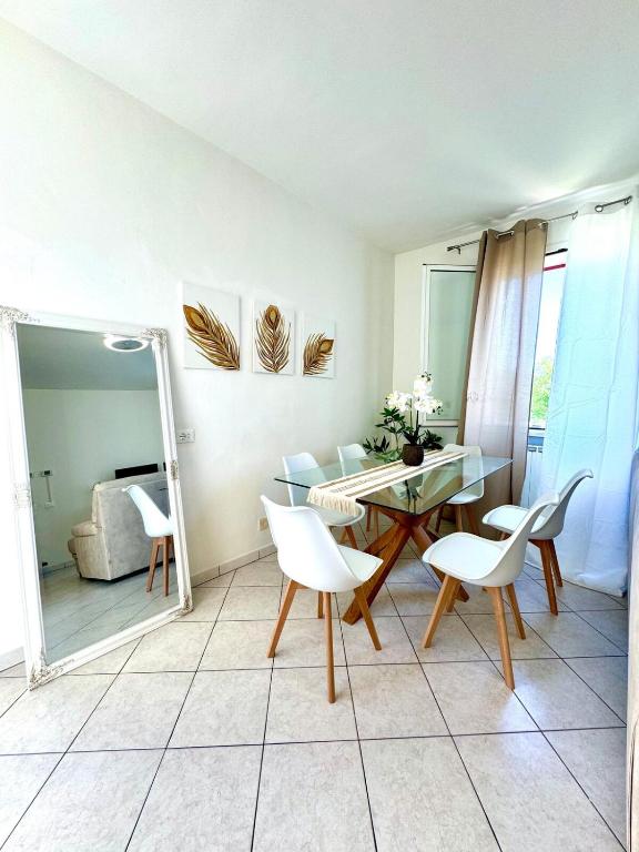 a living room with a table and chairs and a mirror at Appartamento Camelia vista mare in Lido Adriano