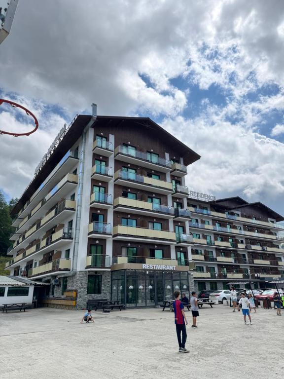 un grupo de personas de pie frente a un gran edificio en Bakuriani Crystal Residence 625, en Bakuriani