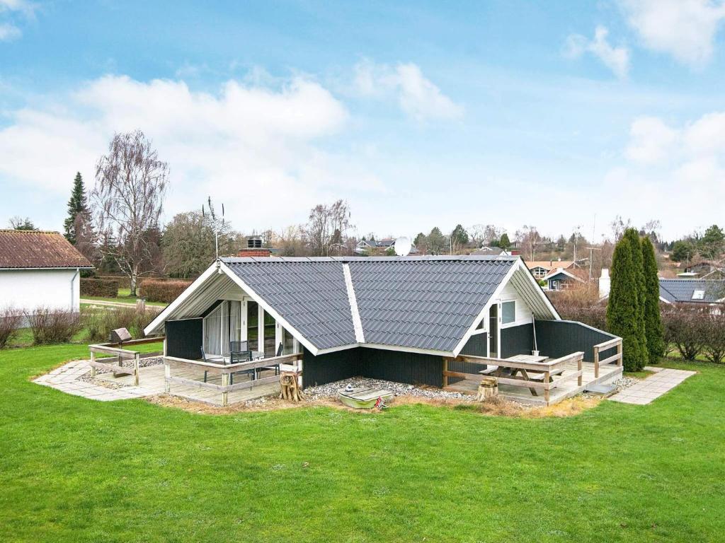 6 person holiday home in Hejls في Hejls: منزل بسقف معدني على ارض خضراء