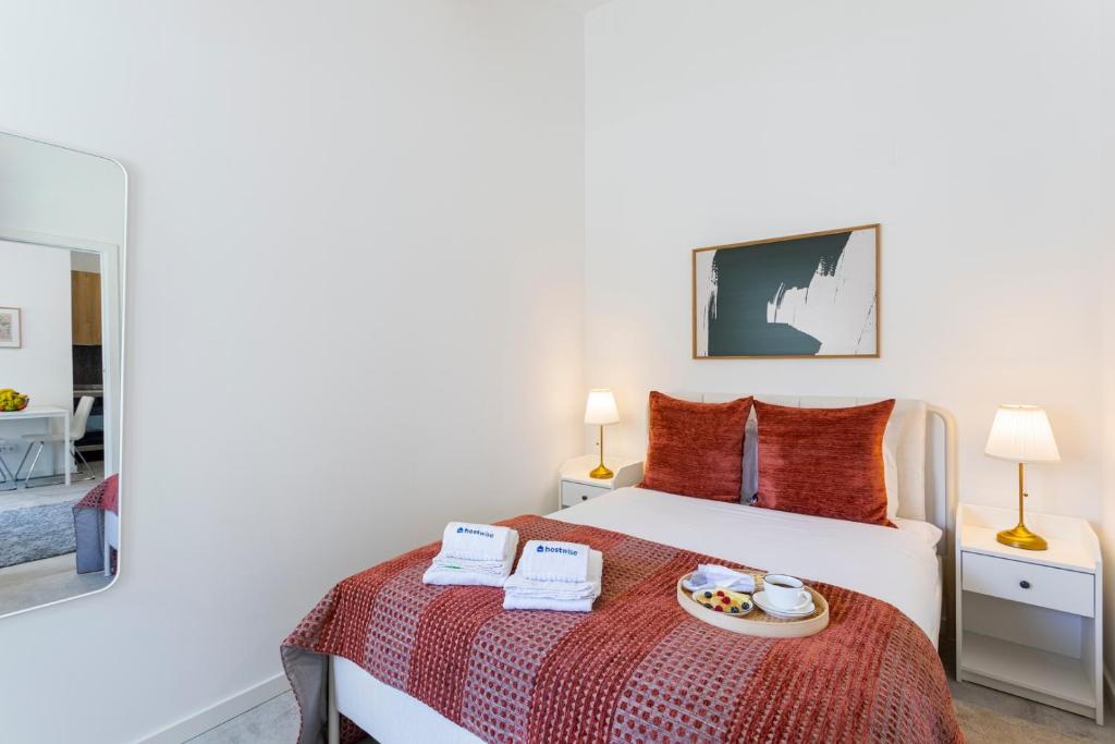 a bedroom with a bed with a plate of food on it at Bright Flat | Romantic Escape by HostWise in Porto