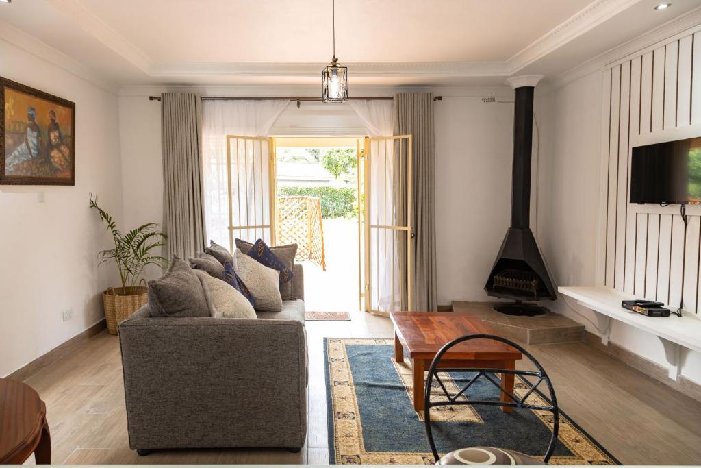 a living room with a couch and a table at 2-Bed Cottage in Mount Pleasant, Harare in Harare