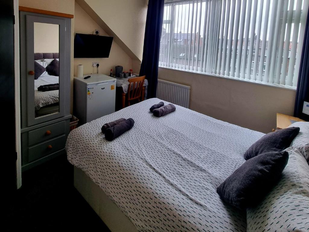 a bedroom with a bed with two pillows on it at Windmill Guest House in Bridlington