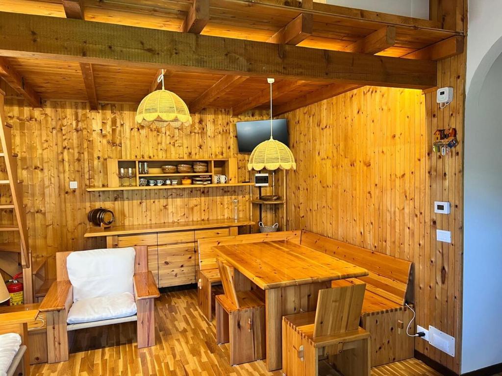 Un comedor con mesa y sillas de madera. en Wood and Fire Chalet, en Borno