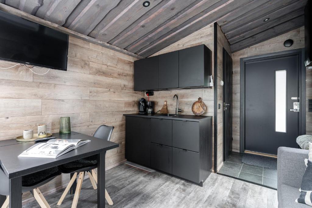 a kitchen with a table and a black cabinet at Koskisviitti 3 - Private Lakeside Suite with Terrace in Laukaa