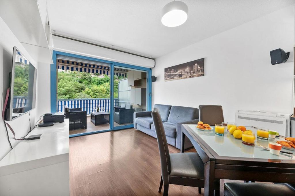 a living room with a table and a couch at Le Virgil - Piscine - Parking Privé - Calme Wifi in Menton